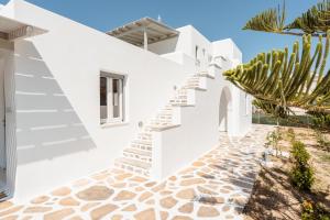 une maison blanche avec des escaliers et un cactus dans l'établissement Celestial Seaview Apartments-Dionysios, à Naxos Chora