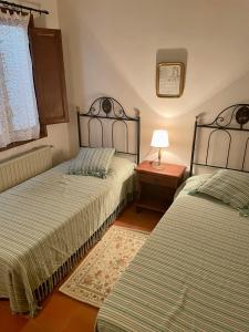 1 dormitorio con 2 camas y mesa con lámpara en Belmonte, en Belmonte de Mezquín