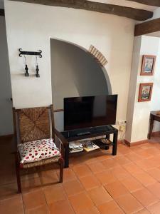 sala de estar con TV de pantalla plana y silla en Belmonte, en Belmonte de Mezquín