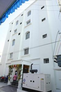 un edificio blanco con una máquina delante en RAJA MAHAL, en Chittoor