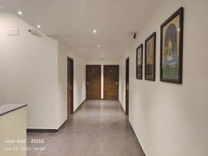 um corredor com paredes brancas e quadros nas paredes em RAJA MAHAL em Chittoor
