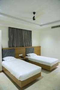 1 dormitorio con 2 camas y ventana en RAJA MAHAL, en Chittoor