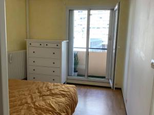 ein Schlafzimmer mit einem Bett, einer Kommode und einem Fenster in der Unterkunft ParisTour Eiffel Beaugrenelle in Paris
