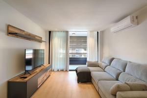 a living room with a couch and a flat screen tv at Apartament Girona Center in Girona