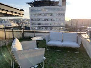 un balcón con 2 sofás y una mesa y un edificio en Apartament Plac Kaszubski en Gdynia