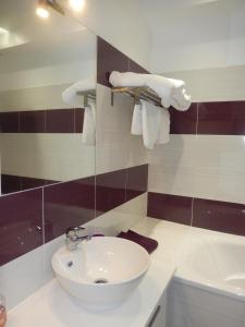 La salle de bains est pourvue d'un lavabo blanc et d'une baignoire. dans l'établissement Domaine de Puyrousse, à Ribérac