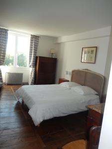 a bedroom with a bed and two windows at Domaine de Puyrousse in Ribérac