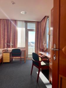 a hotel room with a desk and a bed and a window at Motel Barka in Koper