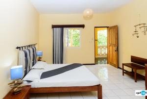 a bedroom with a large bed and a piano at Hôtel Restaurant Coco Lodge Majunga in Mahajanga