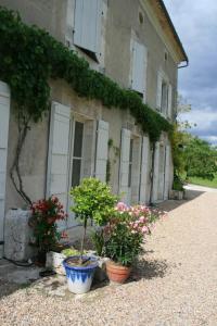 un bâtiment avec des fleurs et des plantes devant lui dans l'établissement Domaine de Puyrousse, à Ribérac