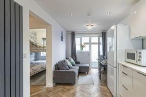 a kitchen and living room with a couch and a bed at The Cove in Holyhead