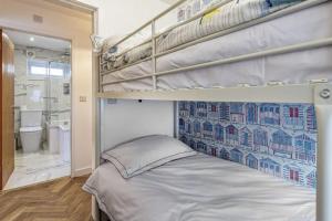 a bedroom with two bunk beds and a bathroom at The Cove in Holyhead