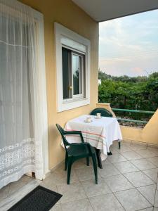 a table and chairs on a balcony with a window at Eden Apartments in Qeparo