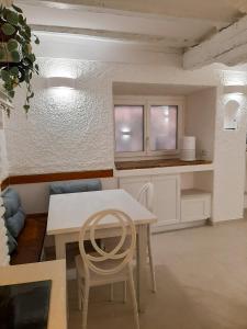 une cuisine avec une table blanche et deux chaises dans l'établissement Camera La Bicocca - centro di Sirolo, à Sirolo