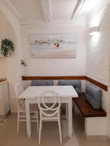 una sala da pranzo con tavolo e sedie bianchi di Camera La Bicocca - centro di Sirolo a Sirolo