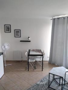 Cette chambre dispose d'une table, de chaises et d'un mur blanc. dans l'établissement Appartement proche Disney Paris, à Montévrain