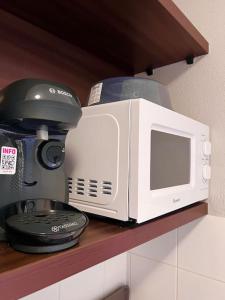 a microwave sitting on a shelf next to a coffee maker at B309 Appartement proche Disney Paris in Montévrain