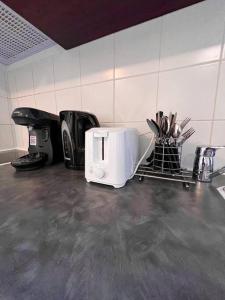 a kitchen counter with a toaster and utensils at Appartement proche Disney Paris in Montévrain