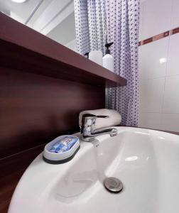 La salle de bains est pourvue d'un lavabo blanc avec un robinet. dans l'établissement Appartement proche Disney Paris, à Montévrain