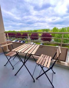 a picnic table and two chairs on a balcony at Appartement proche Disney Paris in Montévrain