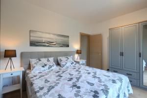 1 dormitorio con 1 cama con colcha azul y blanca en Villa Nona Nina en Poreč