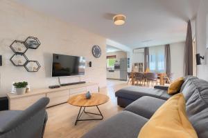 a living room with a couch and a tv at Villa Nona Nina in Poreč