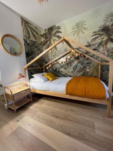 a bedroom with a wooden bed with a canopy at A 10 mn de Disney Land Paris Appartement neuf in Bussy-Saint-Georges