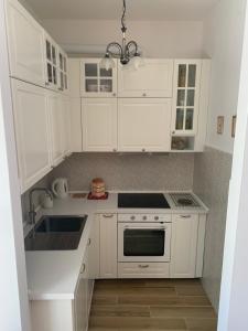 a white kitchen with white cabinets and a sink at Valdonica - Relax in campagna in La Spezia