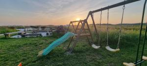 a playground with a slide in a field at Yourtes 6 personnes proche provins et disney in Bannost +11 photos