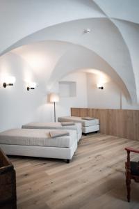 two beds in a room with a white ceiling at ADLER Historic Guesthouse in Bressanone