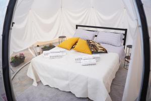 ein Bett mit gelben und weißen Kissen darauf in der Unterkunft Piedigrotta b&b Luxury in Pizzo