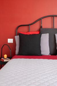 1 dormitorio con 1 cama con pared roja en Le Case di Sonia TRE GEMME RUBINO Fucecchio, en Fucecchio