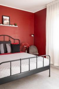 een slaapkamer met een bed en een rode muur bij Le Case di Sonia TRE GEMME RUBINO Fucecchio in Fucecchio