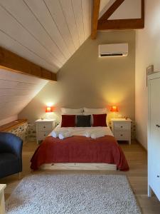 ein Schlafzimmer mit einem großen Bett mit roten Kissen in der Unterkunft Domaine des pierres trouvées in Saint-Vincent