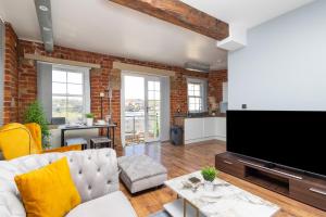 a living room with a couch and a flat screen tv at Au luxury apartment - free parking in Batley