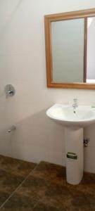 a bathroom with a sink and a mirror and a tub at Aster Suites Kisumu in Awasi