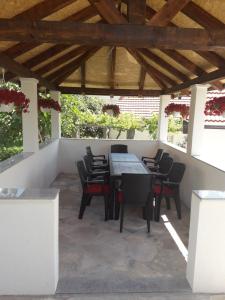 a patio with tables and chairs under a wooden ceiling at Apartman Petar in Trebinje
