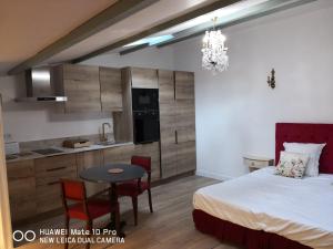 a bedroom with a bed and a table and a kitchen at Hotel Le Saint Laurent in Saint-Laurent-des-Arbres