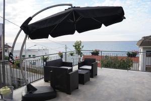 un ombrellone nero su un balcone con vista sull'oceano di Piedigrotta b&b Luxury a Pizzo