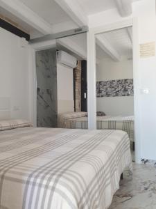 a white bedroom with two beds and a mirror at La Dolce Vita in Castelfidardo