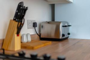 a toaster sitting on top of a wooden counter top at Coventry Stays - Terraced House in Wyken