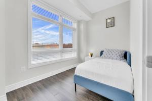 a white bedroom with a bed and a window at Home away from Home - Remote Office in Vaughan