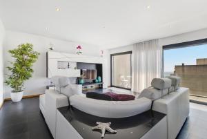 a living room with a white couch and a table at Sublime Mundo Apartamento in Apúlia