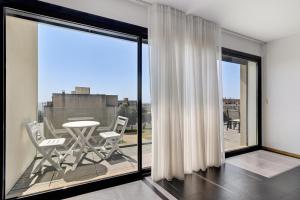 a room with a balcony with a table and chairs at Sublime Mundo Apartamento in Apúlia