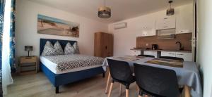 a bedroom with a bed and a table with chairs at Zacisze Apartamenty,Pokoje in Wicie