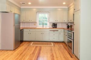 a kitchen with white cabinets and a wooden floor at Dutch Country Acres in New Providence