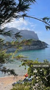 a view of a beach with a mountain in the background at Chambre double cassis in Cassis