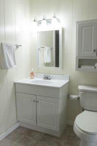 a white bathroom with a sink and a toilet at Tranquility Cottage 