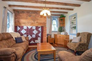 a living room with couches and a brick wall at Cozy Cow in Gettysburg