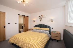 una camera con un letto con una coperta gialla a scacchi di Modern Home in Windermere by LetMeStay a Windermere